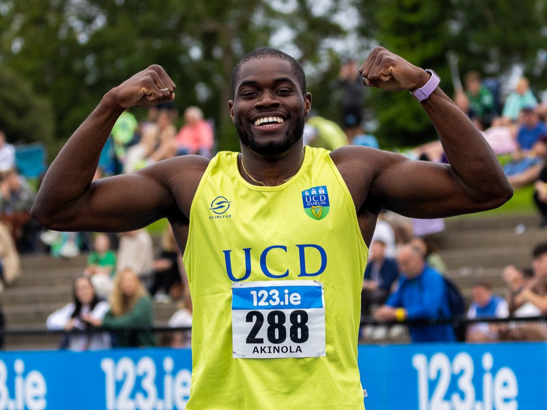 UCD alumnus Bori Akinola smiling and flexing his arms after a race.